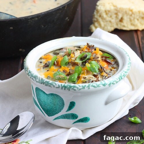 poblano chicken chowder in a green and white bowl garnished with green onions
