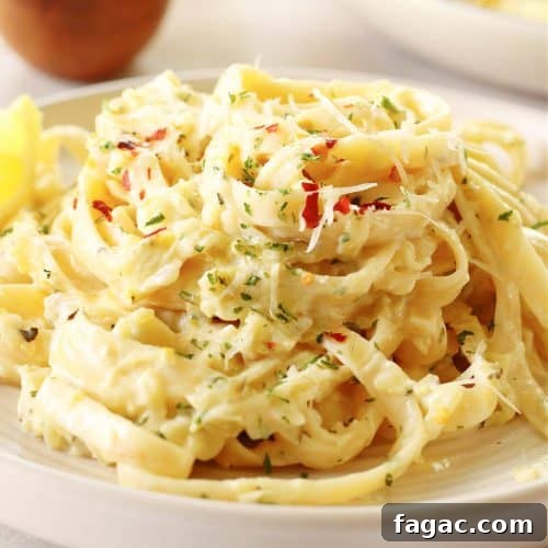 Close up of a serving of creamy zucchini pasta on a plate.