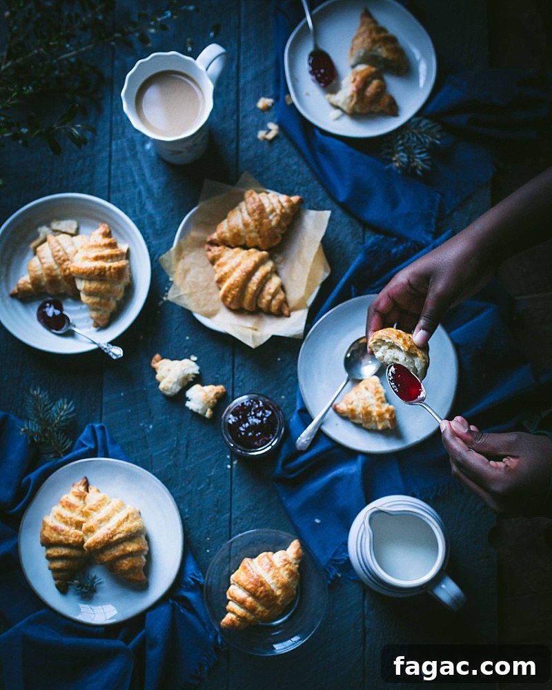 boy puts jam and butter on a croissant