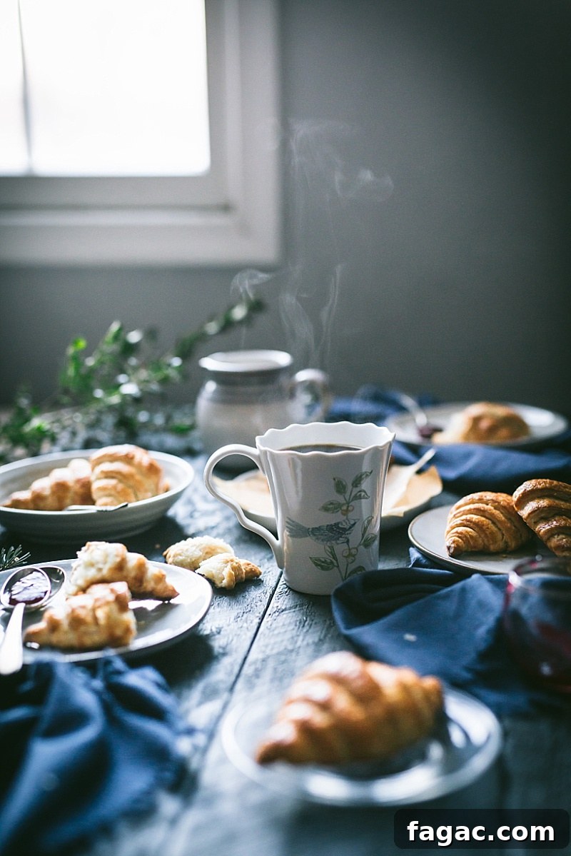 steam rises out of a teacup with croissants