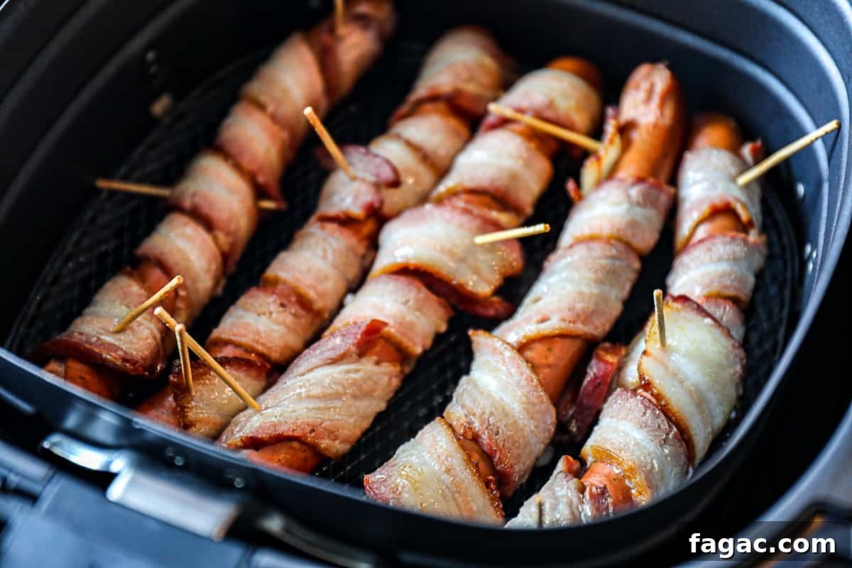 Crispy Bacon-Wrapped Hot Dogs: Air Fryer, Oven & Grill Methods 5 Raw Bacon Wrapped Hot Dogs In Air Fryer Basket.