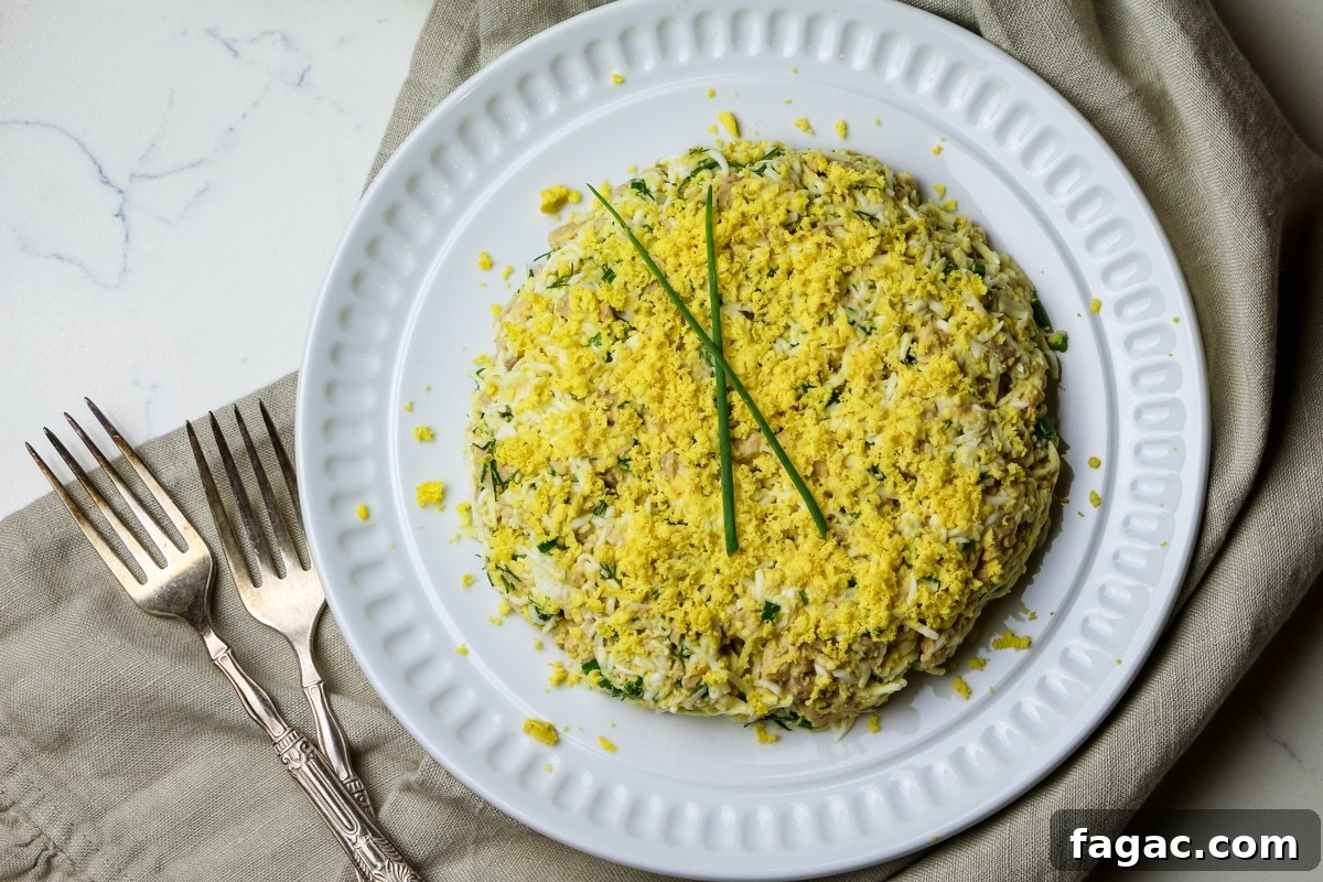 Cod Liver and Egg Salad Recipe: Creamy, Tangy Seafood Salad 12 cod liver and egg salad with two sprigs of green onions on top of white plate.