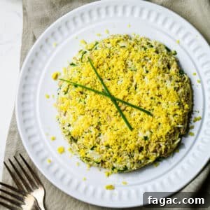 Cod Liver and Egg Salad Recipe: Creamy, Tangy Seafood Salad 13 cod liver salad with eggs on a white plate with two forks in the bottom left corner.