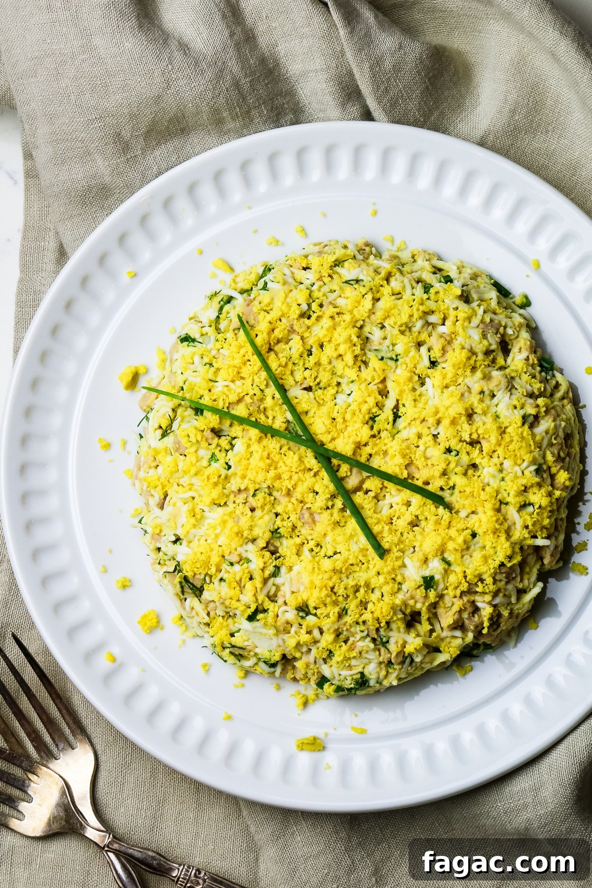Cod Liver and Egg Salad Recipe: Creamy, Tangy Seafood Salad 6 cod liver salad with eggs and green onions on a white plate.