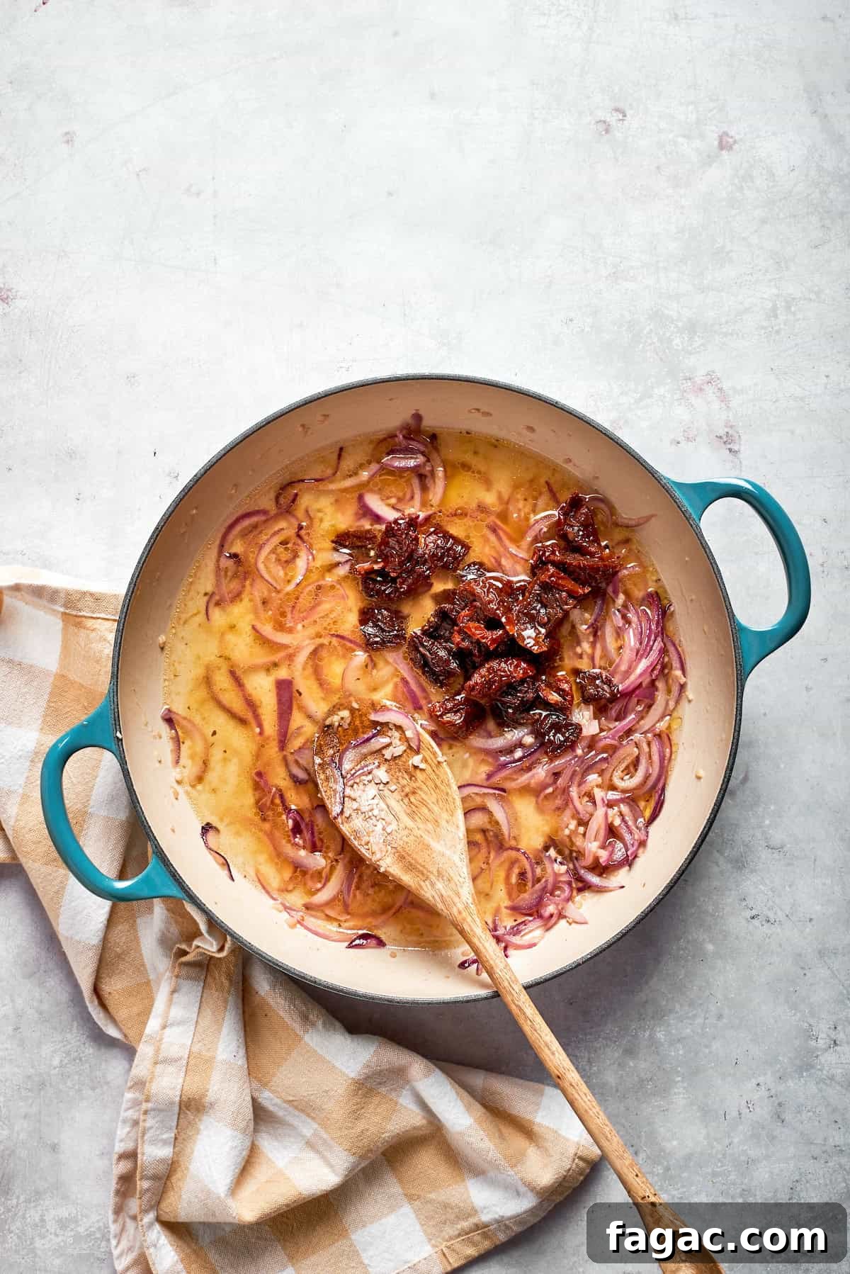 Add broth and tomatoes. Sundried tomatoes are stirred into a skillet.