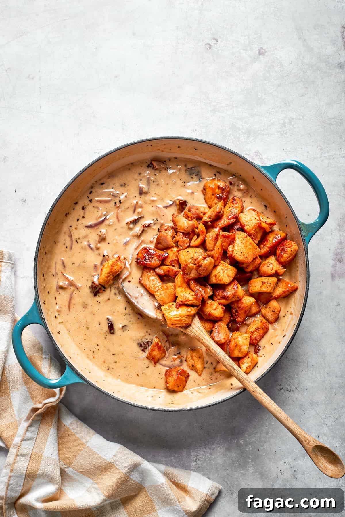Stir in the chicken. Cooked chicken added back to a skillet of cream sauce.