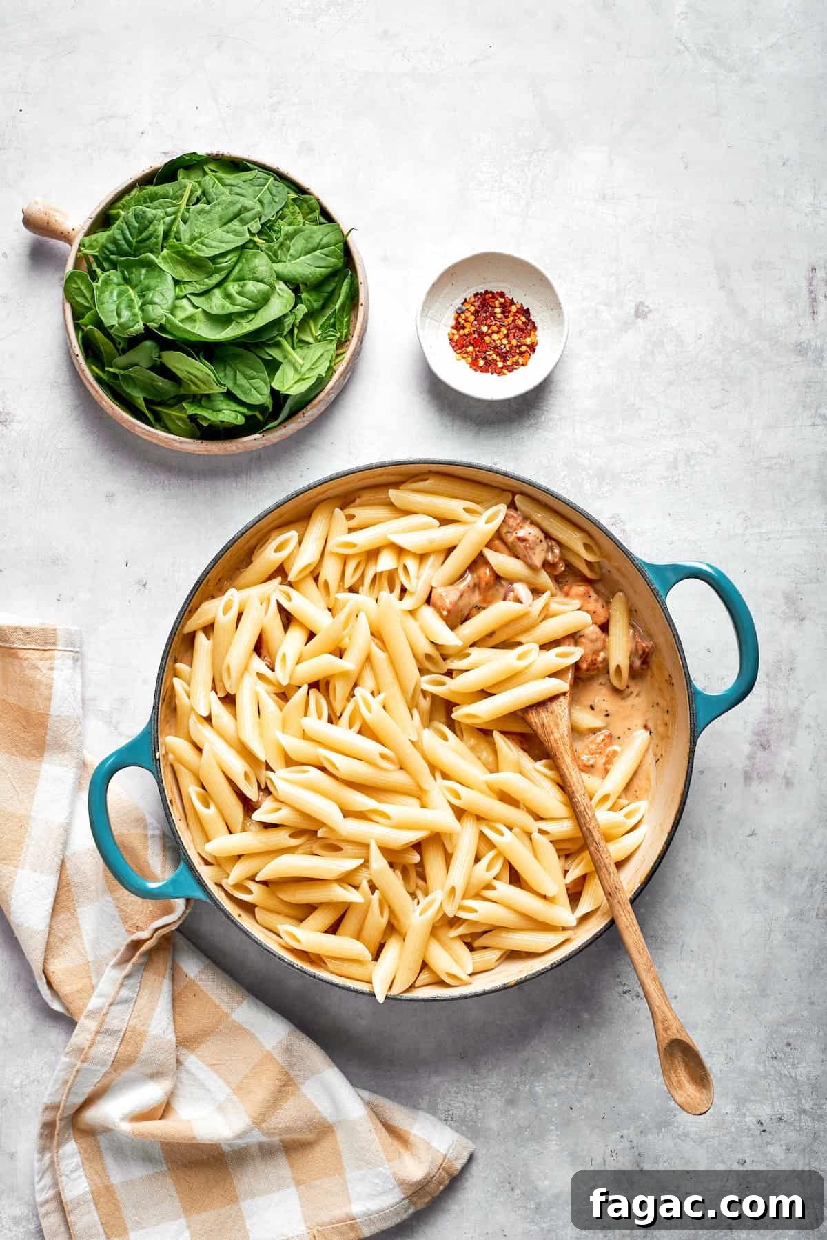 Add pasta. Pasta is stirred into cream sauce in a skillet.
