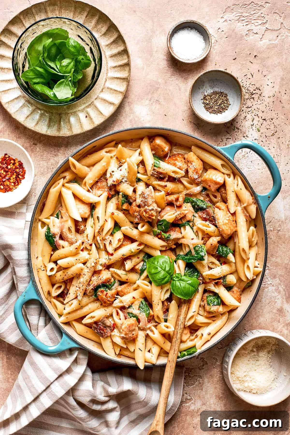 Cheesy, marry me chicken pasta features tender bites of chicken swirled in a creamy sauce along with sundried tomatoes and pasta. A skillet of marry me chicken pasta on a table.