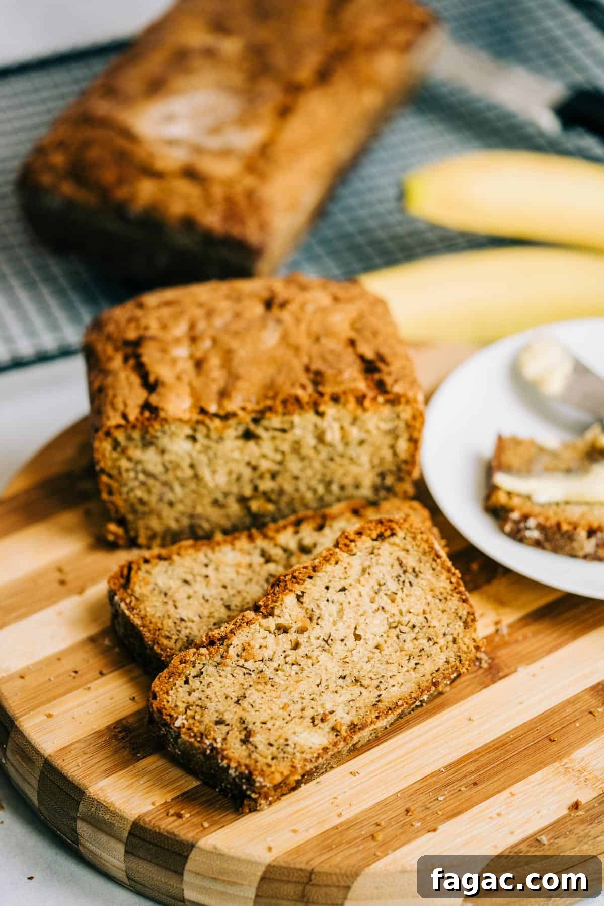 Crispy Sugar-Topped Banana Walnut Bread Recipe 2 Loaf of banana bread and 2 slices on a striped wood cutting board