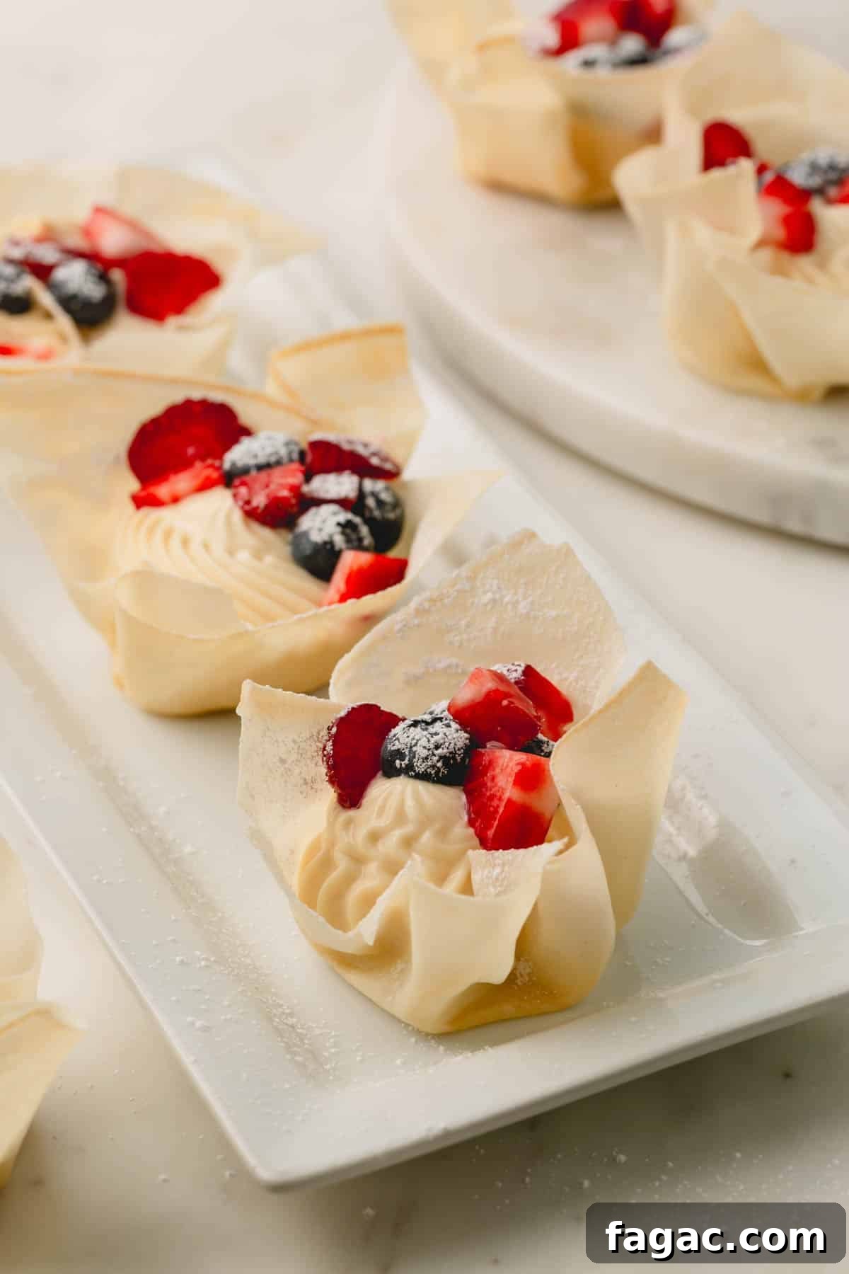 Quick Berry Tartlets: Simple Fresh Fruit Pastry Recipe 10 Platters of mini berry tartlets topped with strawberries, blueberries, and powdered sugar.