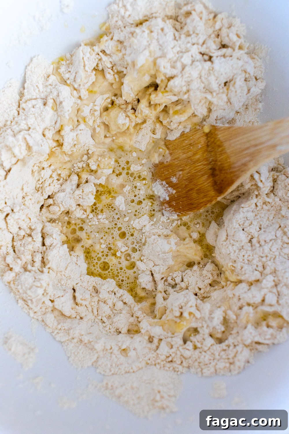 30-Minute Homemade Pizza Dough Recipe for Crispy Crust 6 mixing pizza dough with wooden spoon