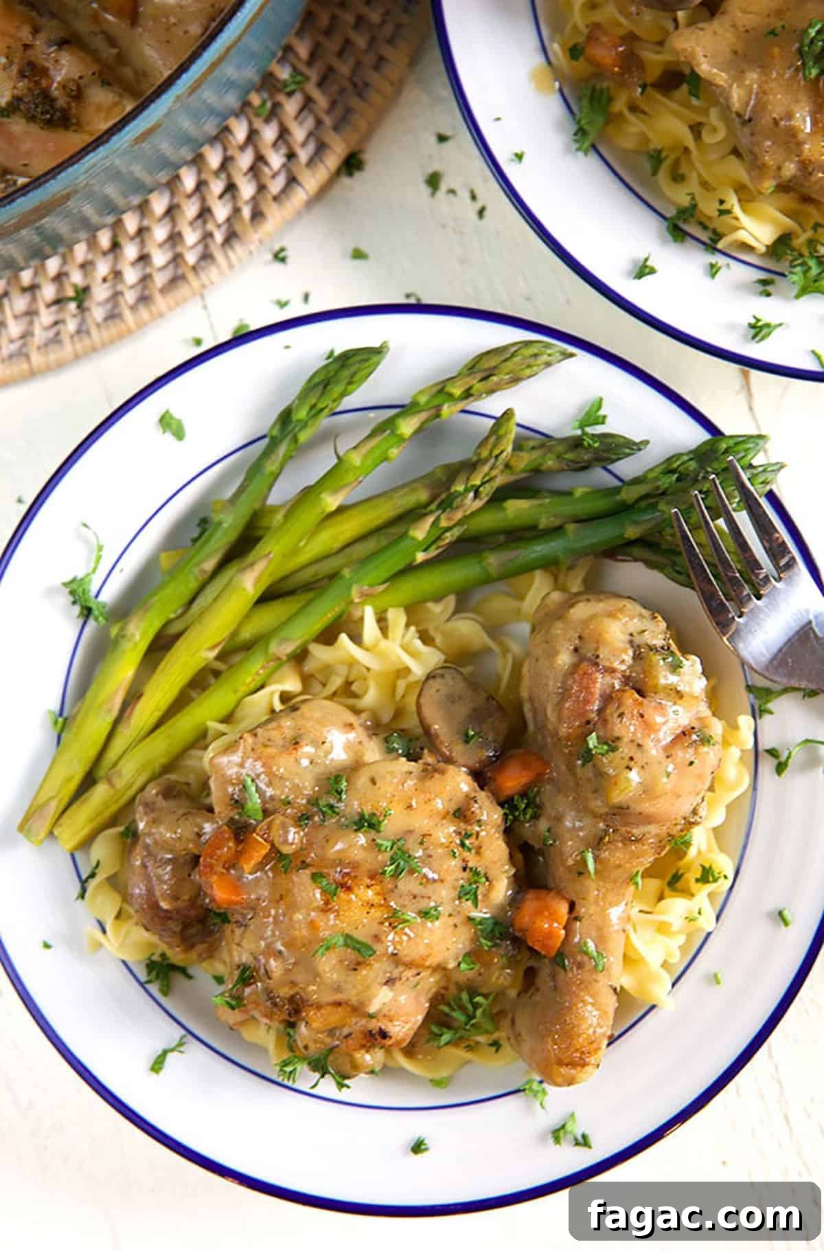 Classic Chicken Fricassee Recipe: Creamy One-Pot French Comfort Meal 4 A fork sits on a plate with asparagus and chicken, ready to be eaten.