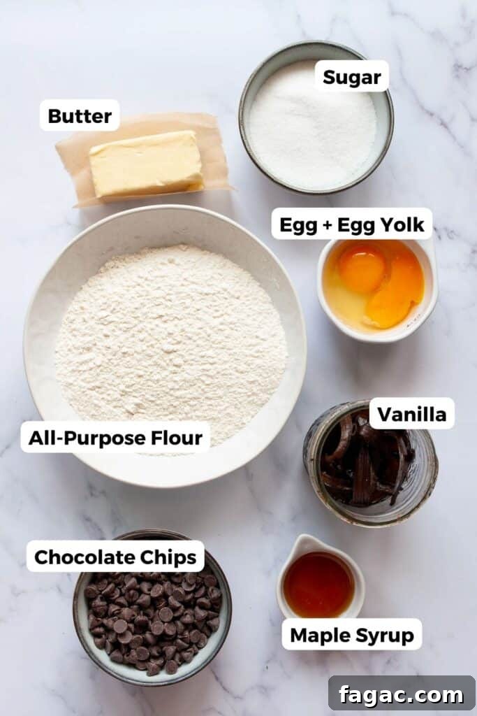 all ingredients in chocolate chip cookies without brown sugar including butter, sugar, flour, eggs, maple syrup, chocolate chips, and vanilla extract