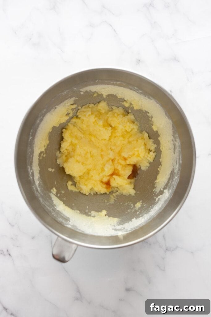 adding eggs and vanilla to beaten butter and white sugar