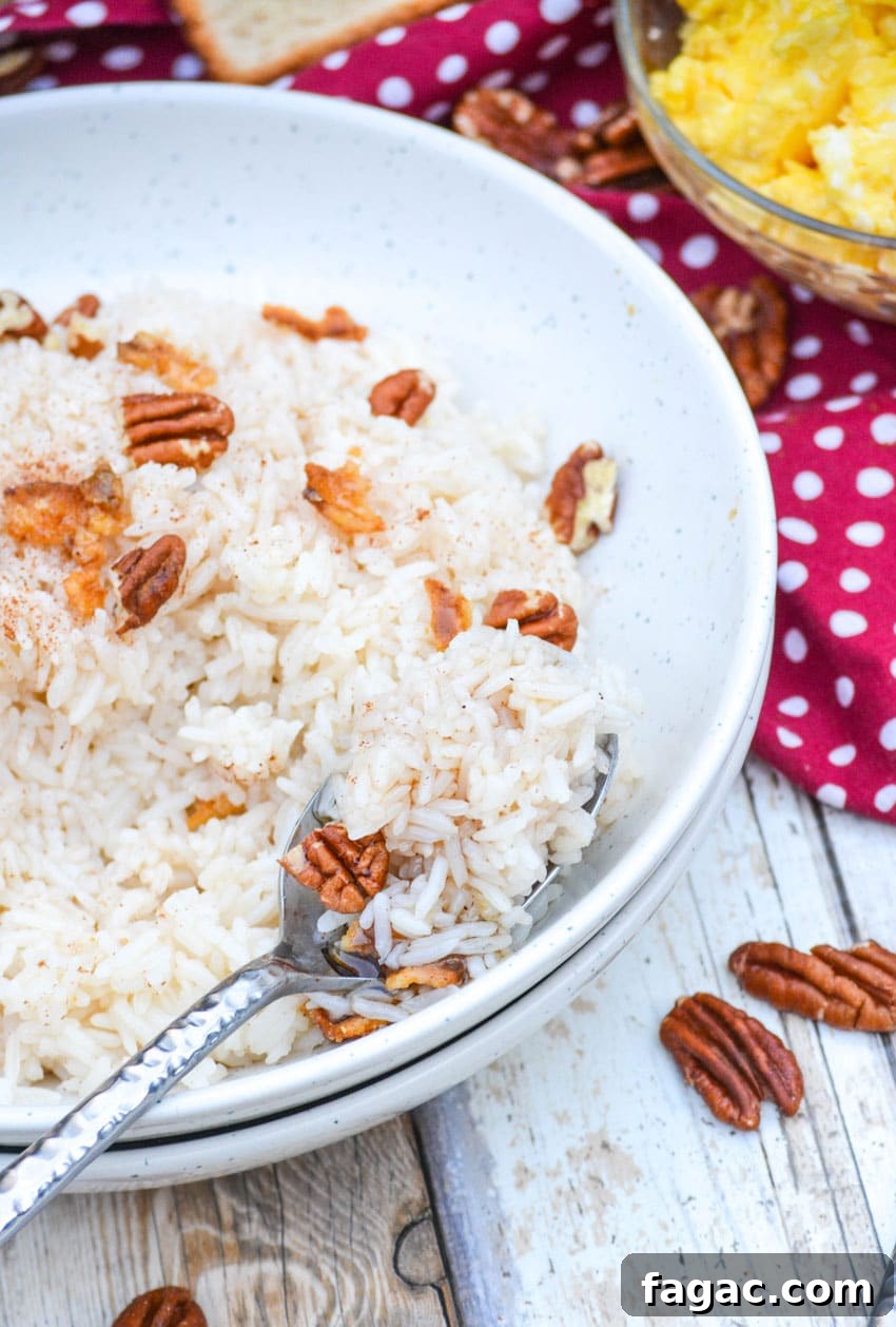 Savory Breakfast Rice Bowl with Veggies and Eggs 5 a silver spoon digging into a white bowl filled with breakfast rice