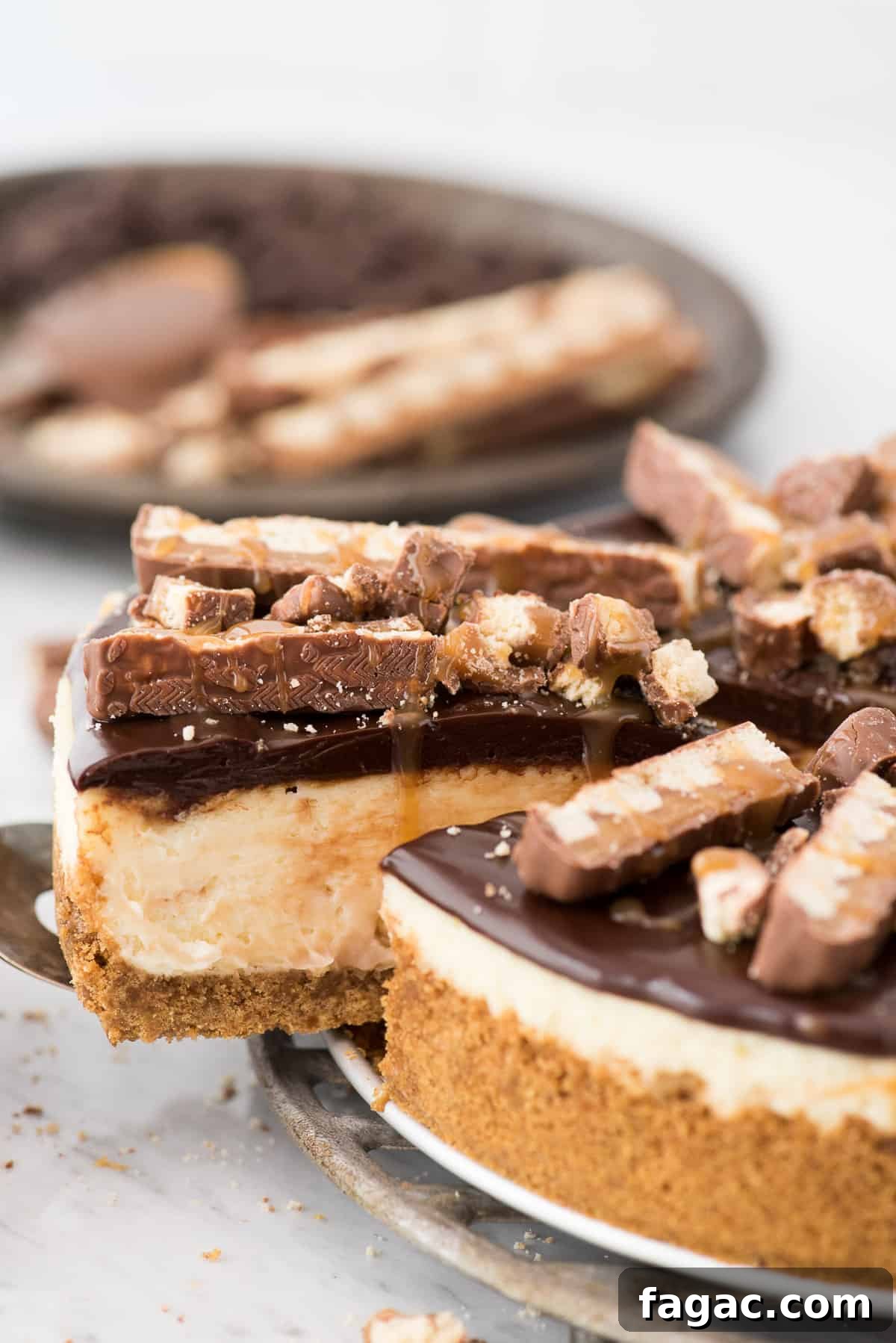 Creamy Twix cheesecake with caramel swirl, chocolate ganache and Twix pieces Twix cheesecake with ganache and caramel