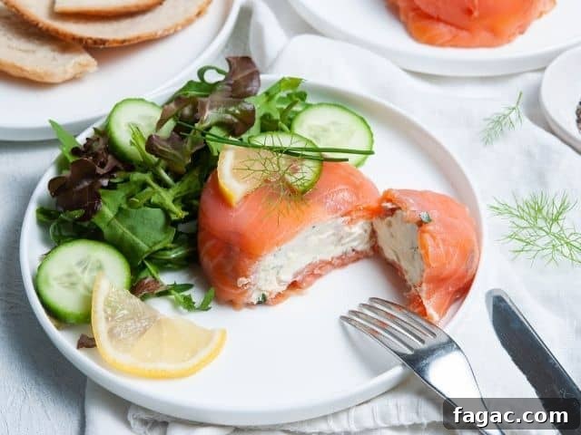 parcel cut in half, showing cream cheese filling, sitting on a plate with some salad and a wedge of lemon.