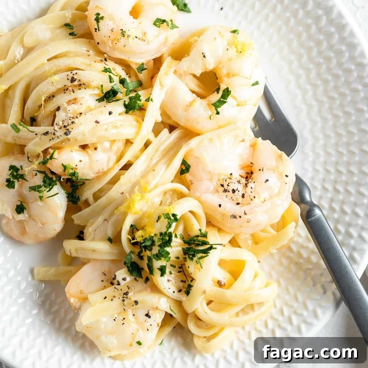 Round white plate with a serve of pasta, with a fork on the side.
