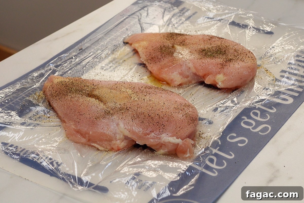 Juicy Oven-Baked Chicken Breasts with Garlic and Herbs 5 Two chicken breasts with seasoning.