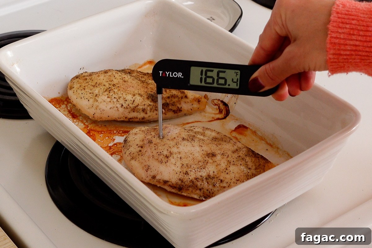 Juicy Oven-Baked Chicken Breasts with Garlic and Herbs 6 A woman checking the internal temperature of a chicken breast.