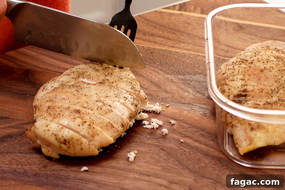 Juicy Oven-Baked Chicken Breasts with Garlic and Herbs 7 A woman slicing a chicken breast.