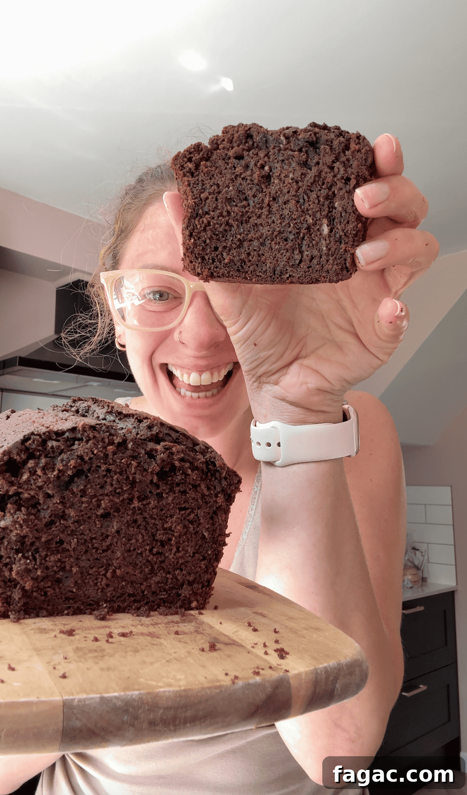 Moist Chocolate Zucchini Cake Recipe 3 Author Sarah Howells holding up a slice of chocolate courgette cake.