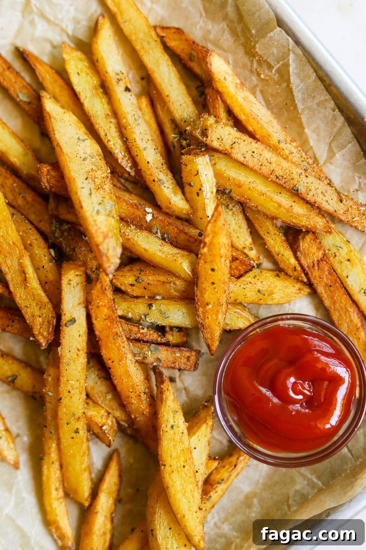 20 Tasty Sides to Serve with Burgers (Healthy Options Included) 4 Classic seasoned french fries with garlic powder, dried basil, paprika, and ketchup on a baking sheet with parchment paper.