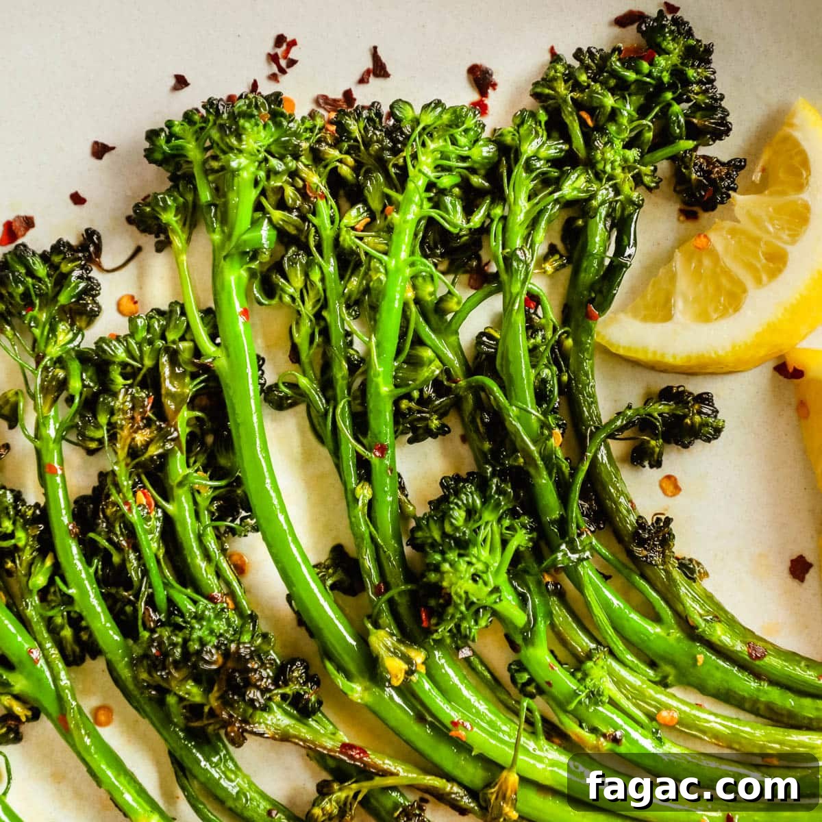 20 Tasty Sides to Serve with Burgers (Healthy Options Included) 7 Closeup of easy delicious charred broccolini/broccoletti on a plate with seasoning, lemon wedges, and chili flakes.