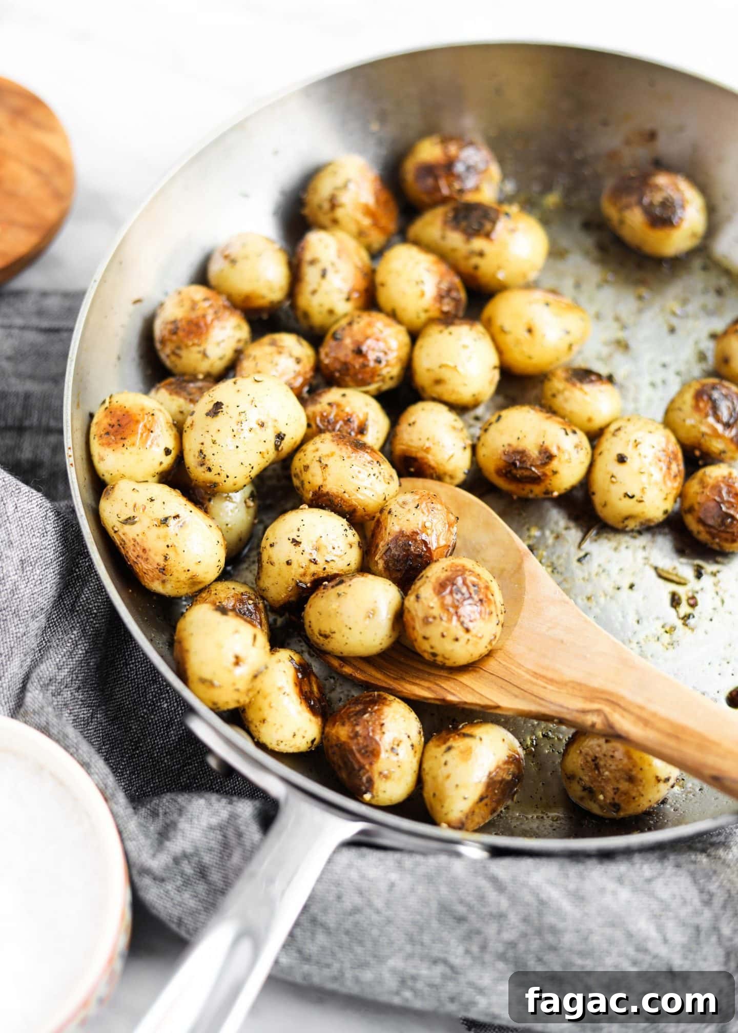 20 Tasty Sides to Serve with Burgers (Healthy Options Included) 8 potatoes roasting in a pan with spoon