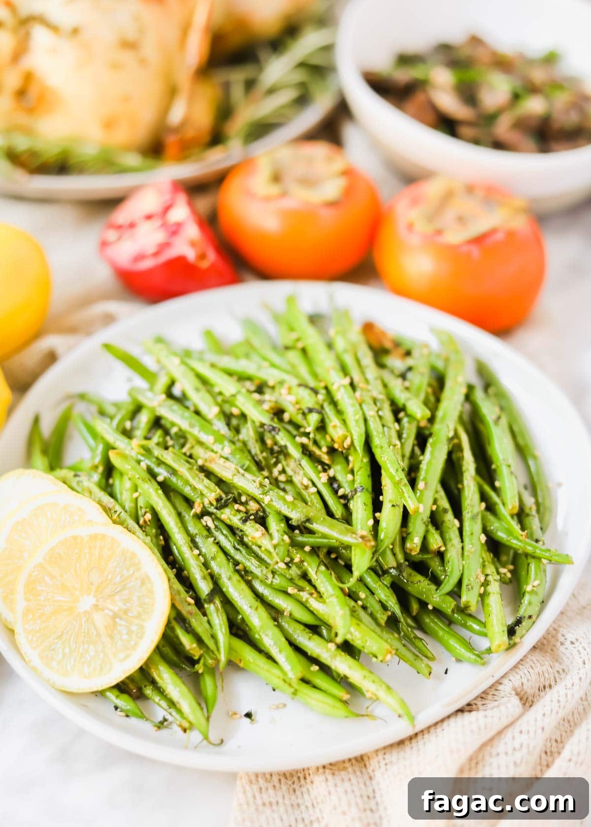 20 Tasty Sides to Serve with Burgers (Healthy Options Included) 10 Sautéed Green Beans with Furikake with lemon wedges on plate.