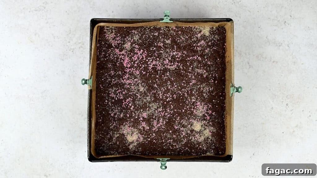 Chocolate crunch cake in square baking tin sprinkled with granulated sugar