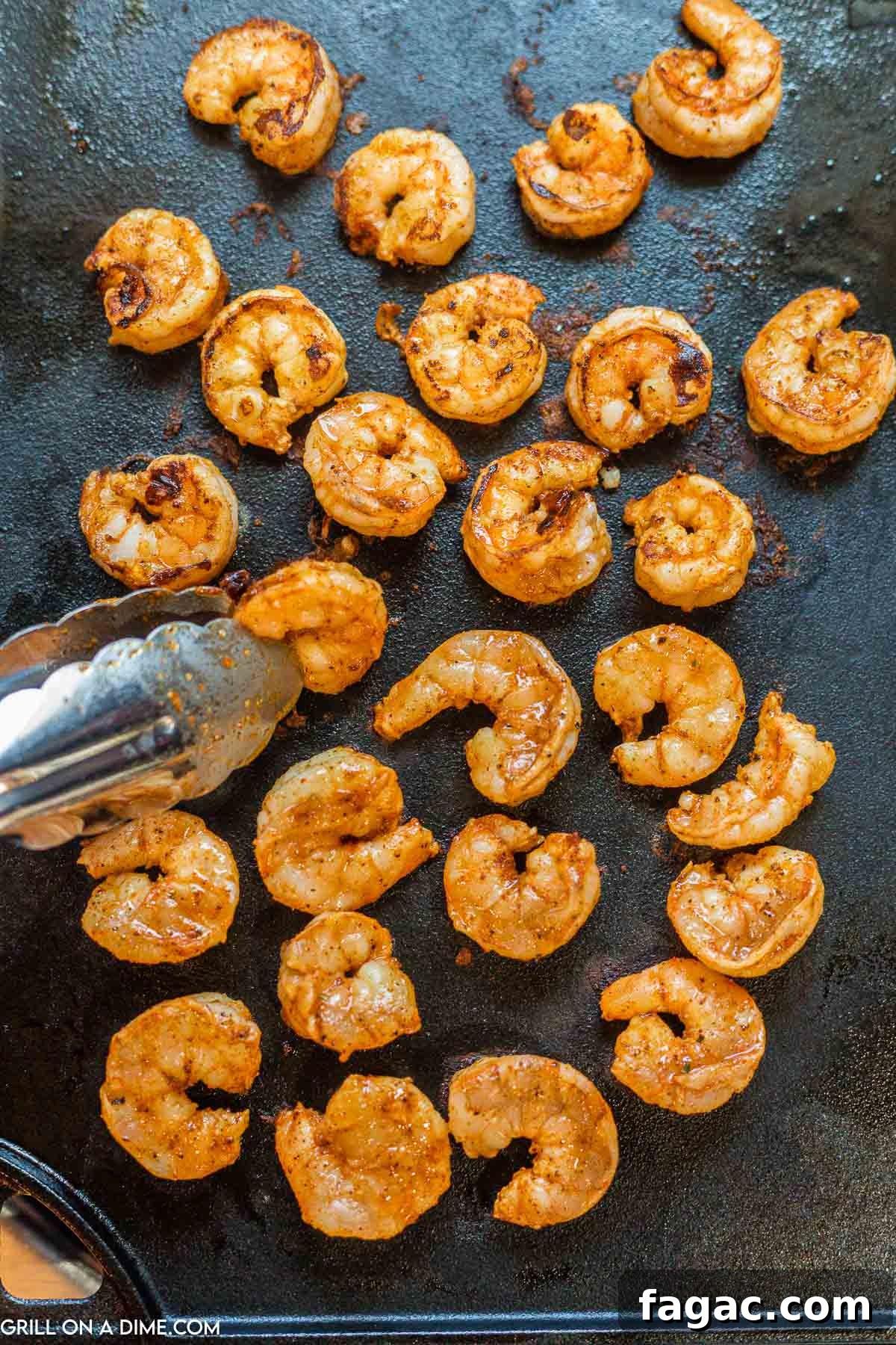 Placing shrimp on grill to cook.