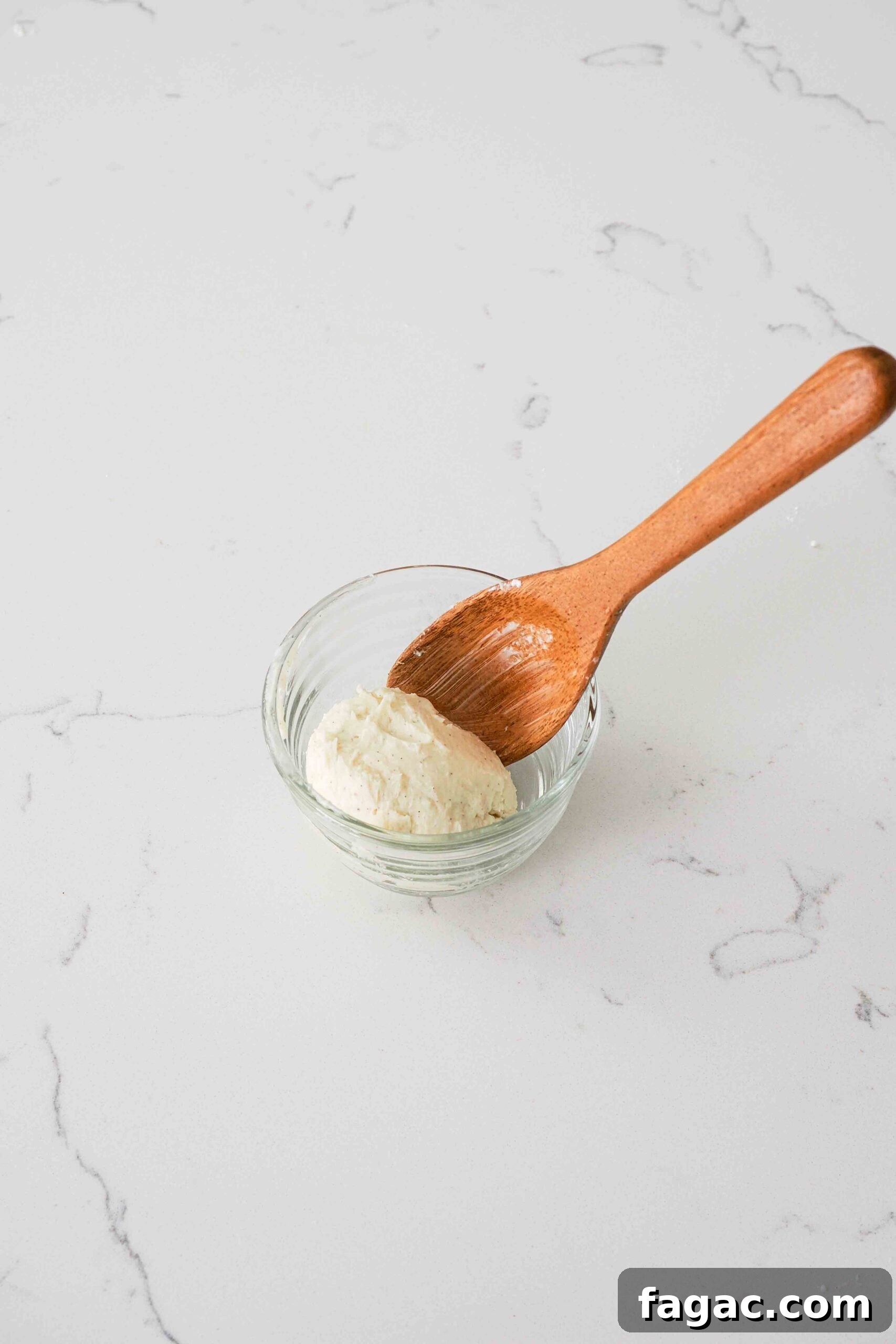 Silky Vanilla Whipped Cream Recipe for Desserts and Toppings 8 A wooden spoon with a sphere of vanilla bean-speckled homemade butter.