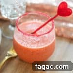Strawberry basil margarita mocktail in a cup with a heart stirrer