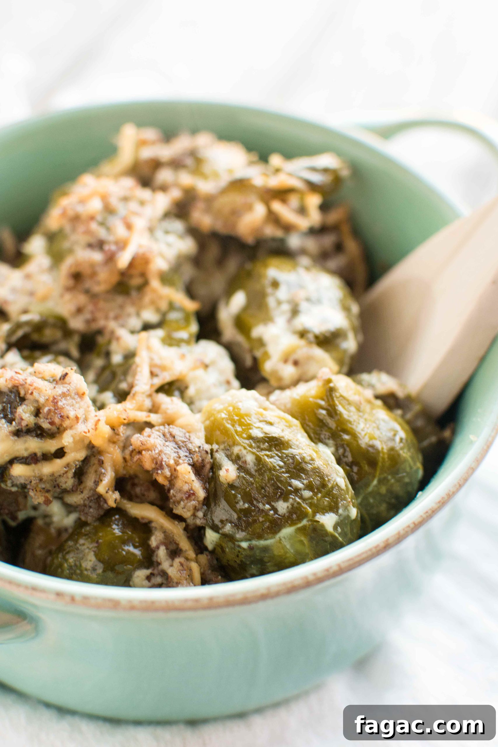 brussels sprouts in green bowl with wooden spoon in bowl