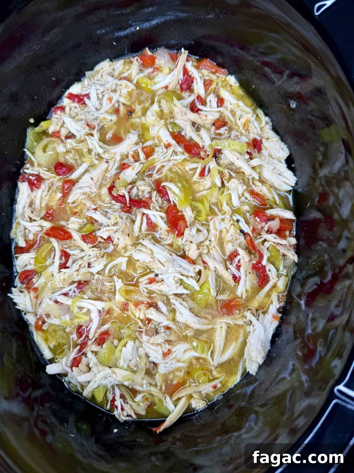 Crockpot Chicken Philly Cheesesteak Recipe for Slow-Cooked Sandwiches 10 Easy Crockpot Chicken Philly Cheesesteak: Shredded chicken mixed with chopped red and green peppers in a slow cooker, surrounded by savory broth.