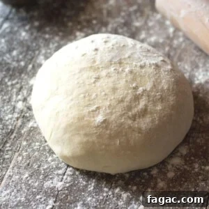 A ball of yeast free pizza dough on a wooden surface