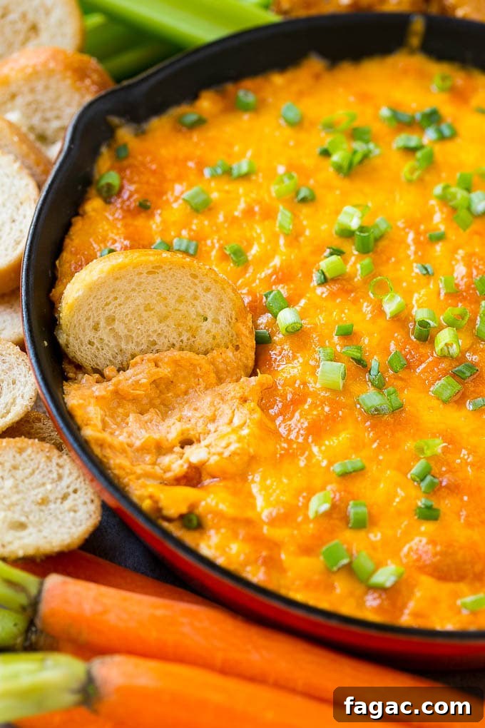 Buffalo Ranch Chicken Dip Buffalo ranch chicken dip with a baguette slice in it.