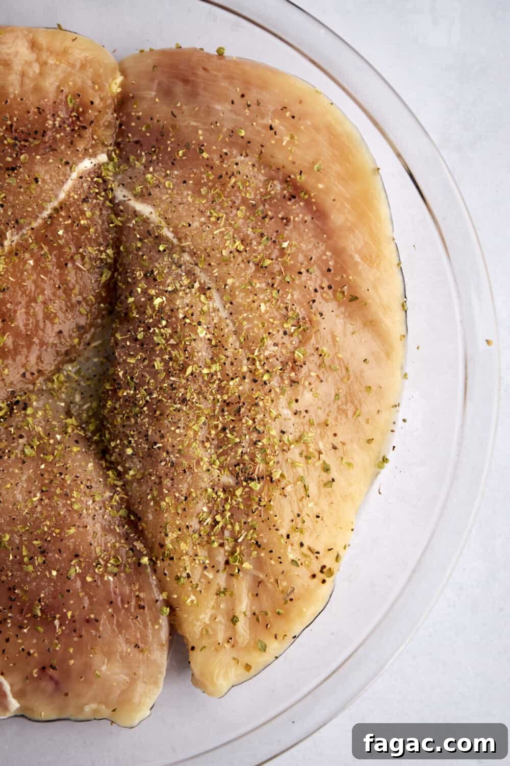 Creamy Parmesan Chicken Recipe – Tender Garlic Butter Chicken 3 raw seasoned chicken breasts in a glass bowl