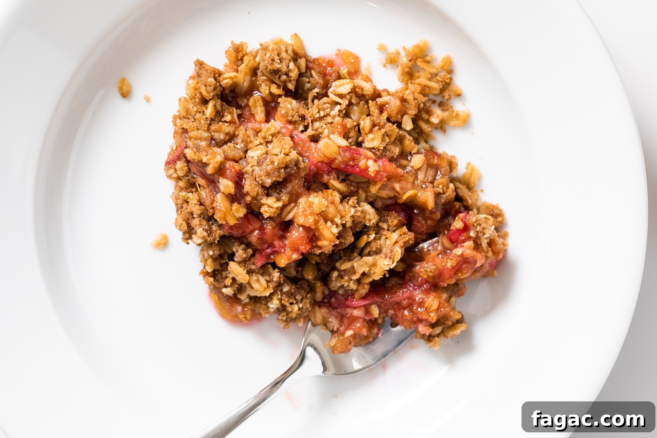 Classic Rhubarb Crisp Recipe with Buttery Oat Topping 6 White plate with rhubarb crisp.