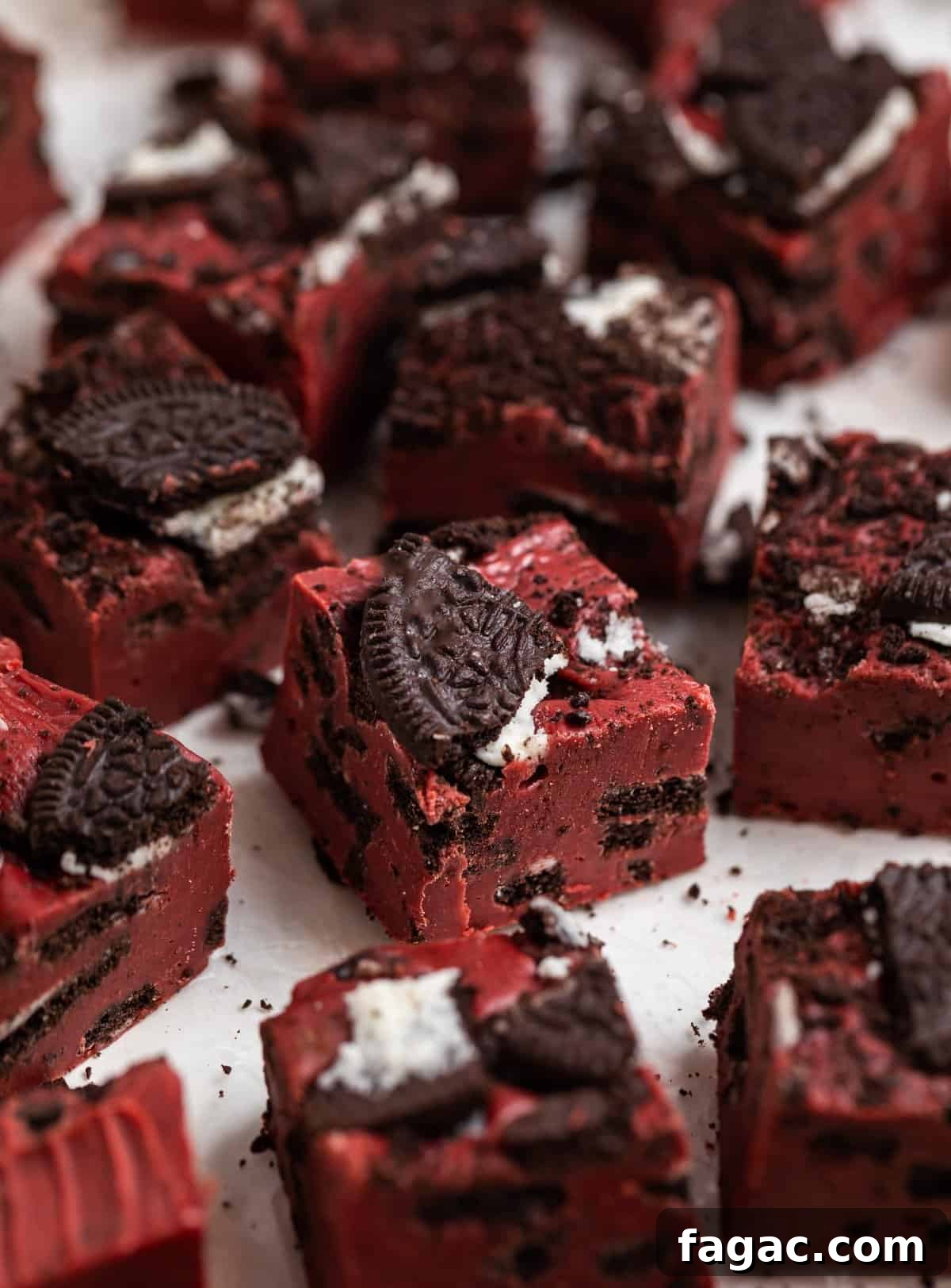 Decadent Red Velvet Oreo Fudge Recipe for Dessert Lovers 2 Red velvet fudge with Oreos sitting on wax paper.
