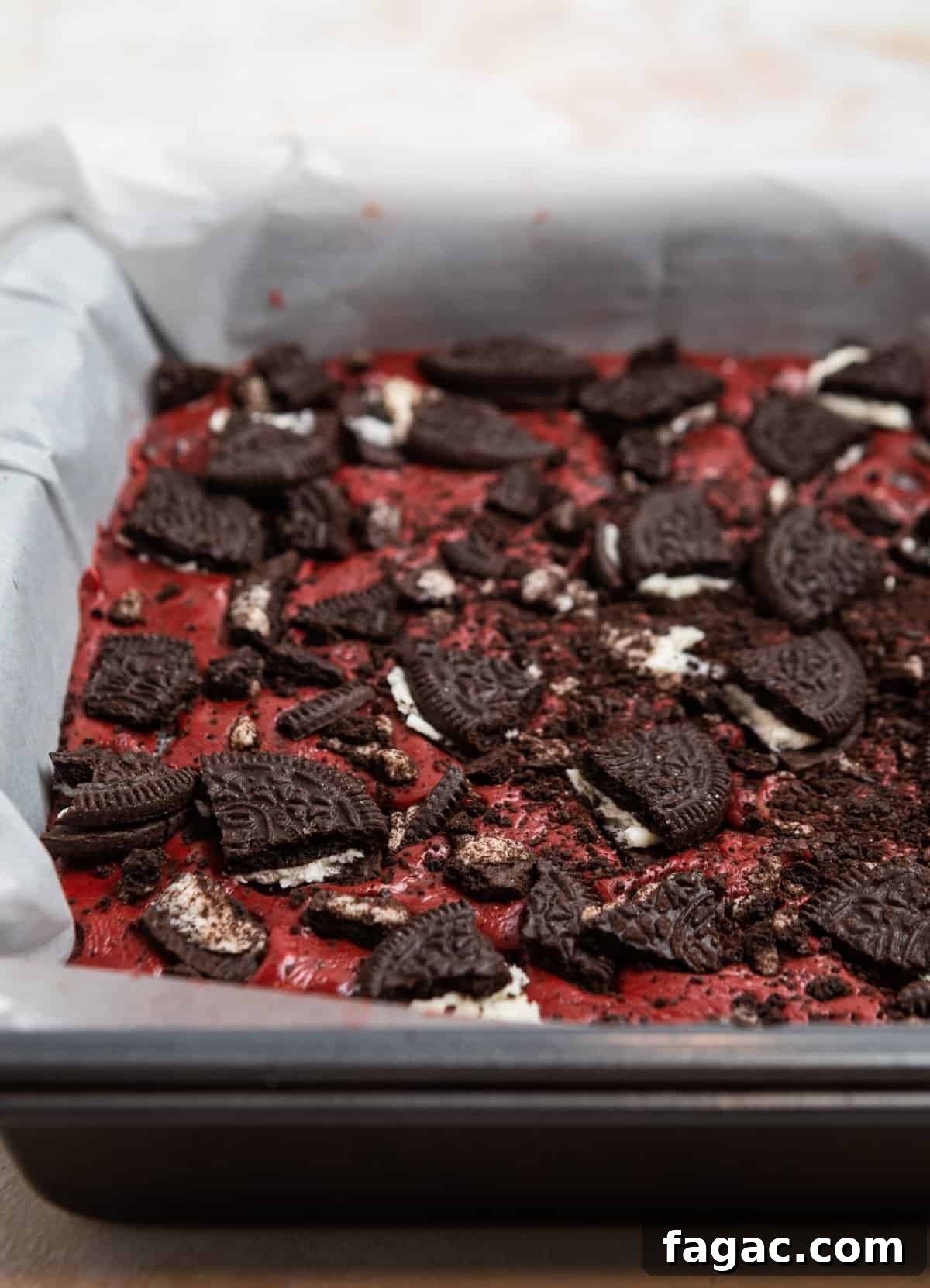 Decadent Red Velvet Oreo Fudge Recipe for Dessert Lovers 8 Oreo red velvet fudge in parchment lined pan and topped with crushed Oreos.