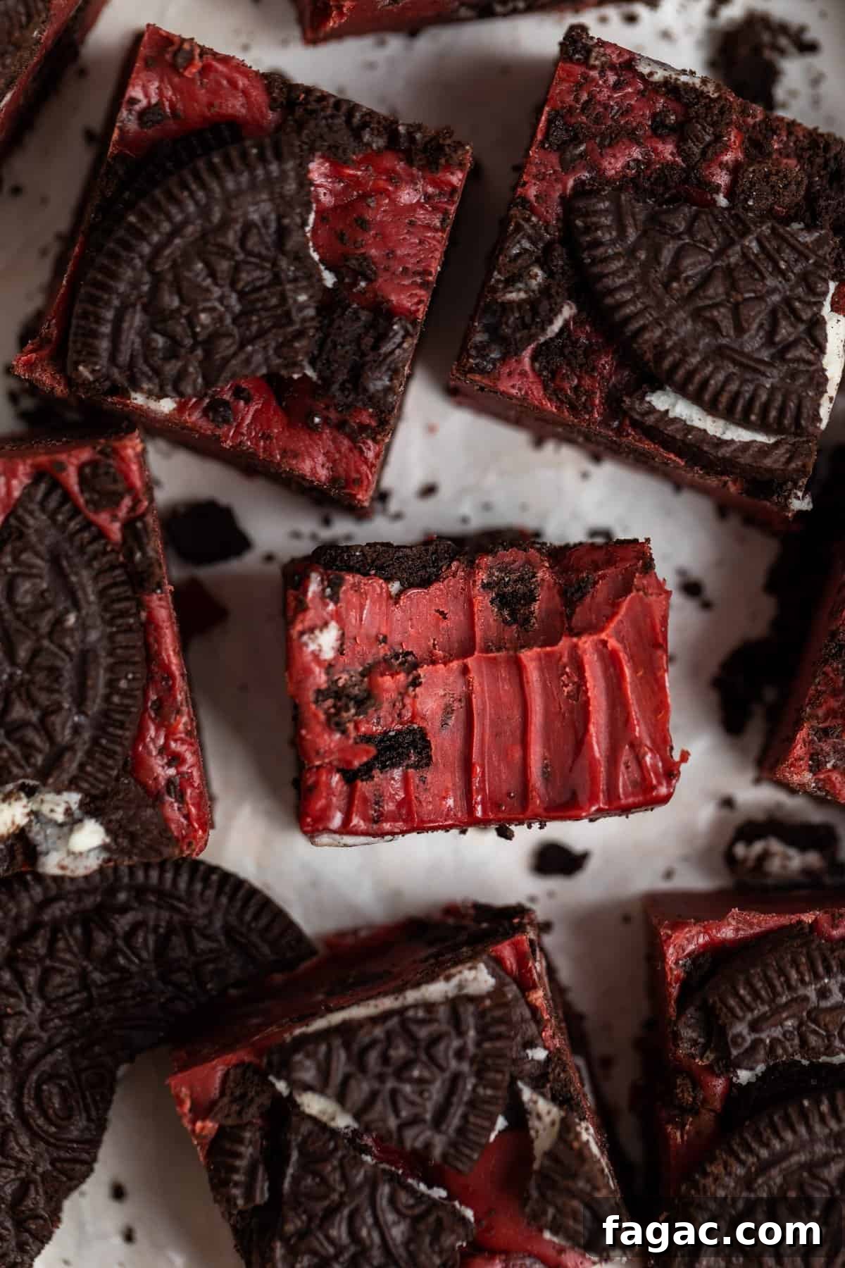 Decadent Red Velvet Oreo Fudge Recipe for Dessert Lovers 9 Bite taken out of Oreo red velvet fudge piece surrounded by other pieces of fudge.