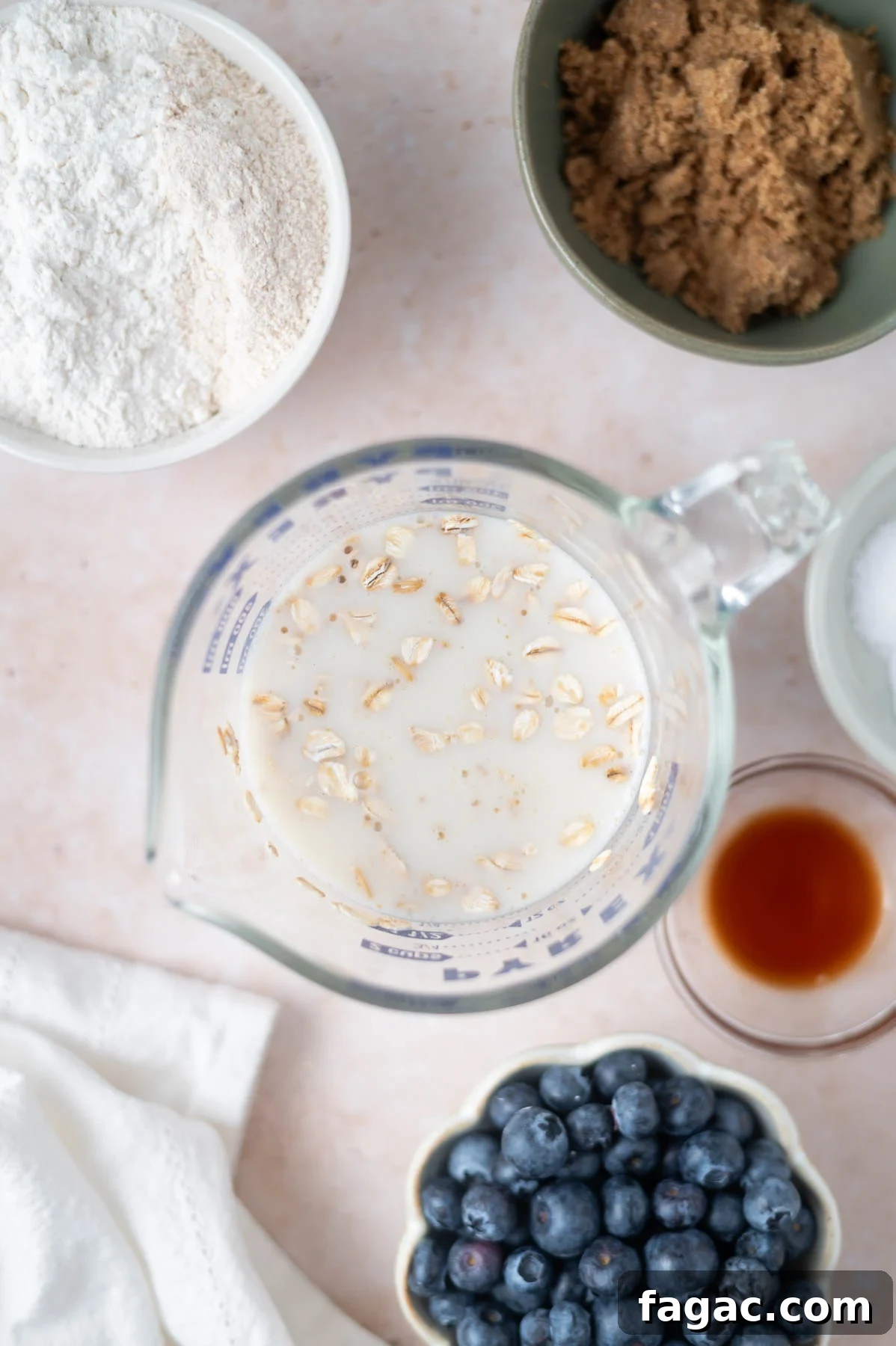 oatmeal in almond milk in a measuring cup with other ingredients nearby