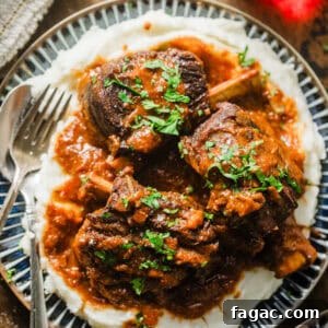 red wine braised short ribs on a plate with mashed potatoes and garnished with parsley.