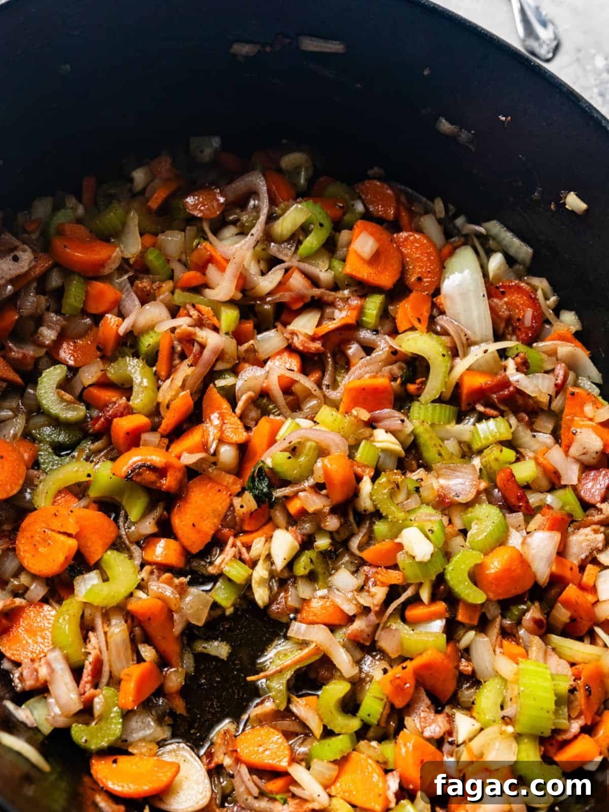 cooked carrots, celery, onions, shallots, and garlic in a pot.