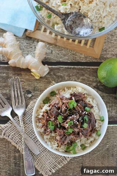Tender, fall off the bone crockpot asian short ribs! This delicious easy recipe is filled with tamari, ginger and garlic. Serve with coconut rice and bok choy for a perfect meal! Slow Cooker Asian Short Ribs over rice in a white bowl.