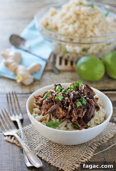 Tender, fall off the bone crockpot asian short ribs! This delicious easy recipe is filled with tamari, ginger and garlic. Serve with coconut rice and bok choy for a perfect meal! Crockpot Beef Short Ribs over rice in a white bowl with forks to the side.