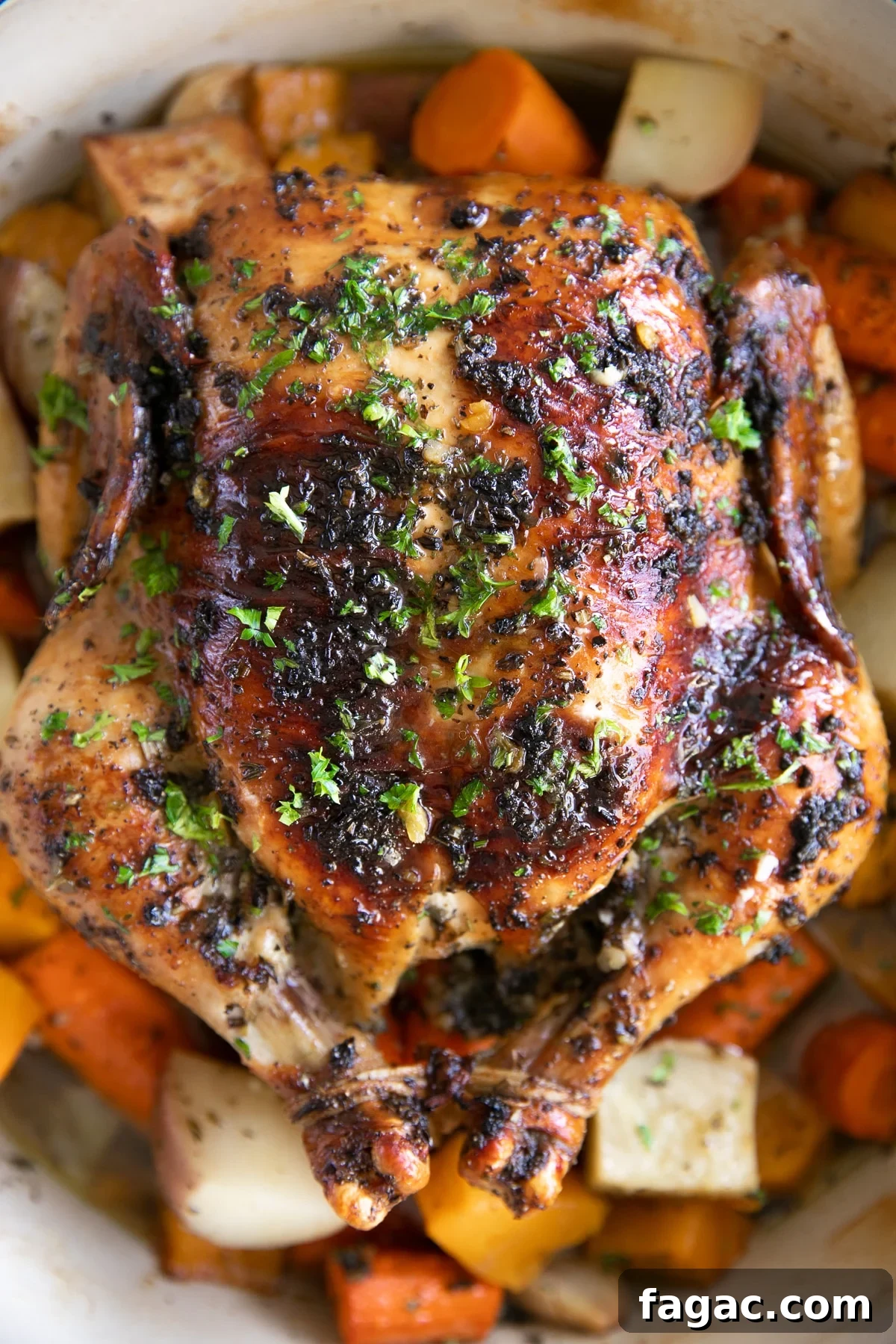 Crispy Roast Chicken with Herb Butter and Lemon 2 Garlic Herb Butter Roast chicken in a large round Dutch oven set atop a bed of vegetables.