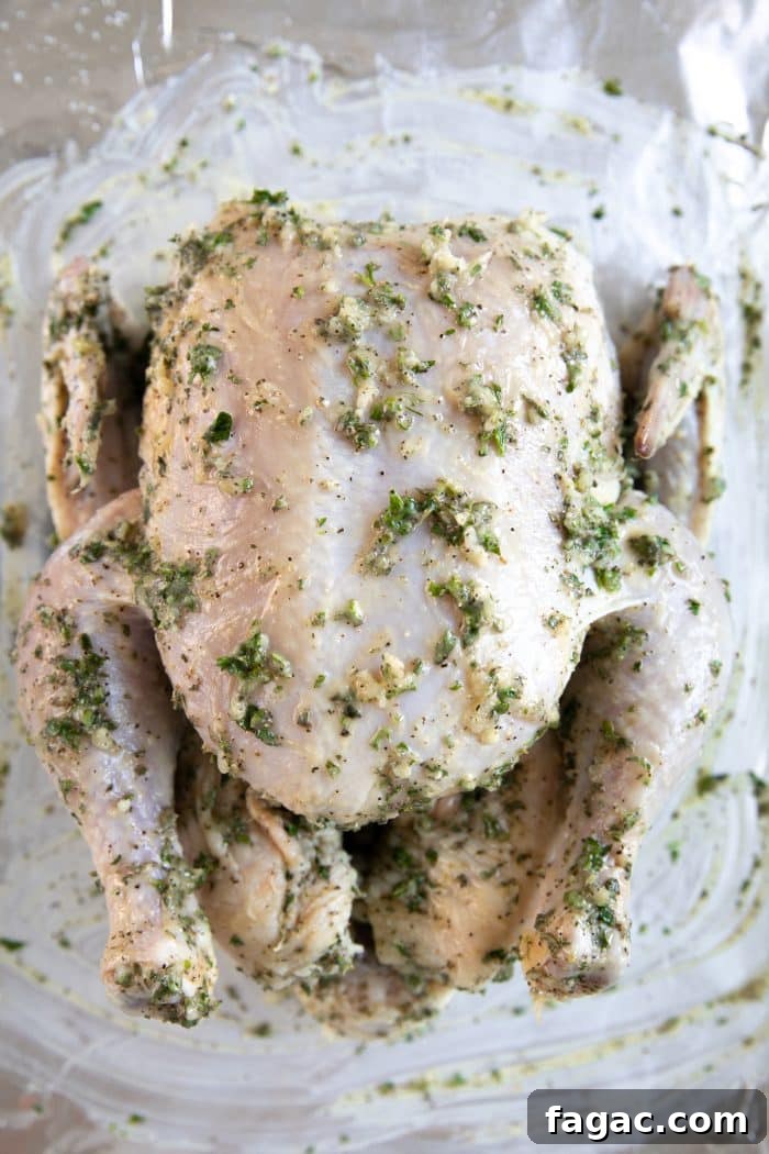 Crispy Roast Chicken with Herb Butter and Lemon 6 Raw chicken on a large baking sheet lined with foil and rubbed with a garlic, butter, and herb mixture.